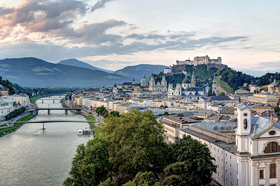 Ein Fluß der durch Salzburg fließt mit verschiedenen Sightseeing Objekten.