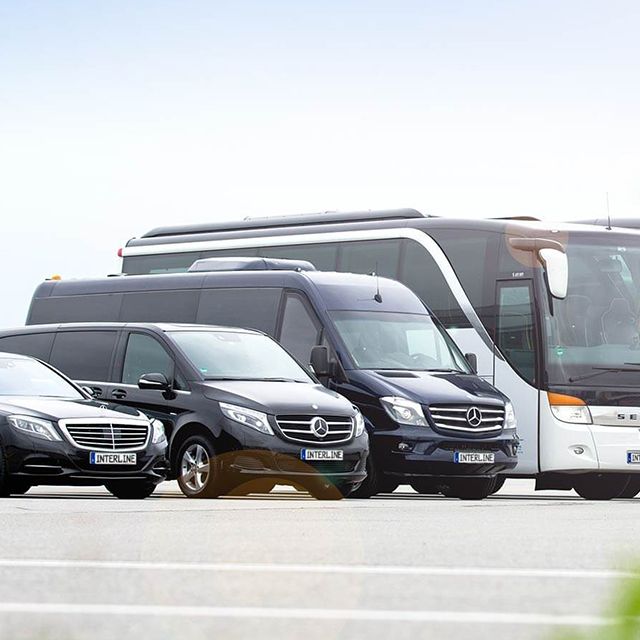 Coaches, Minivans and a Limousine on a airport.