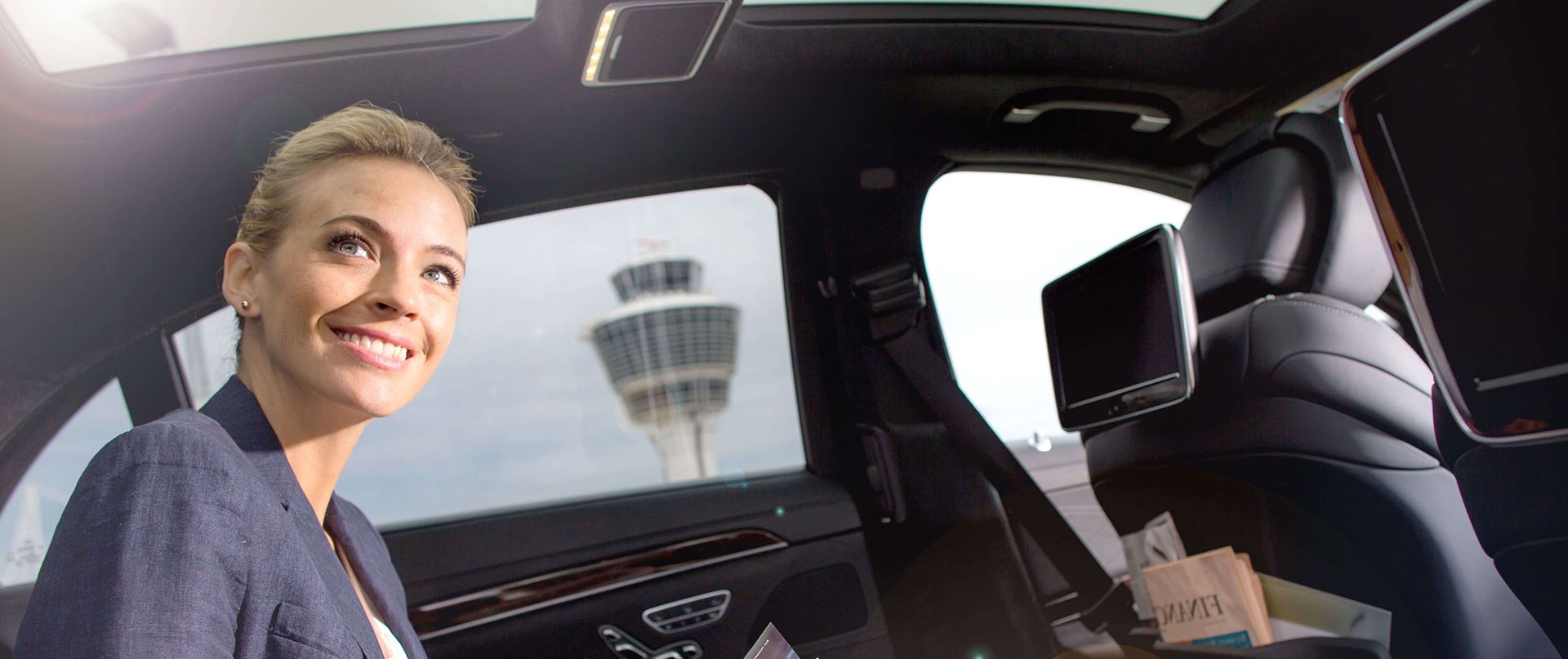 A smiling woman sitting in a limousine.