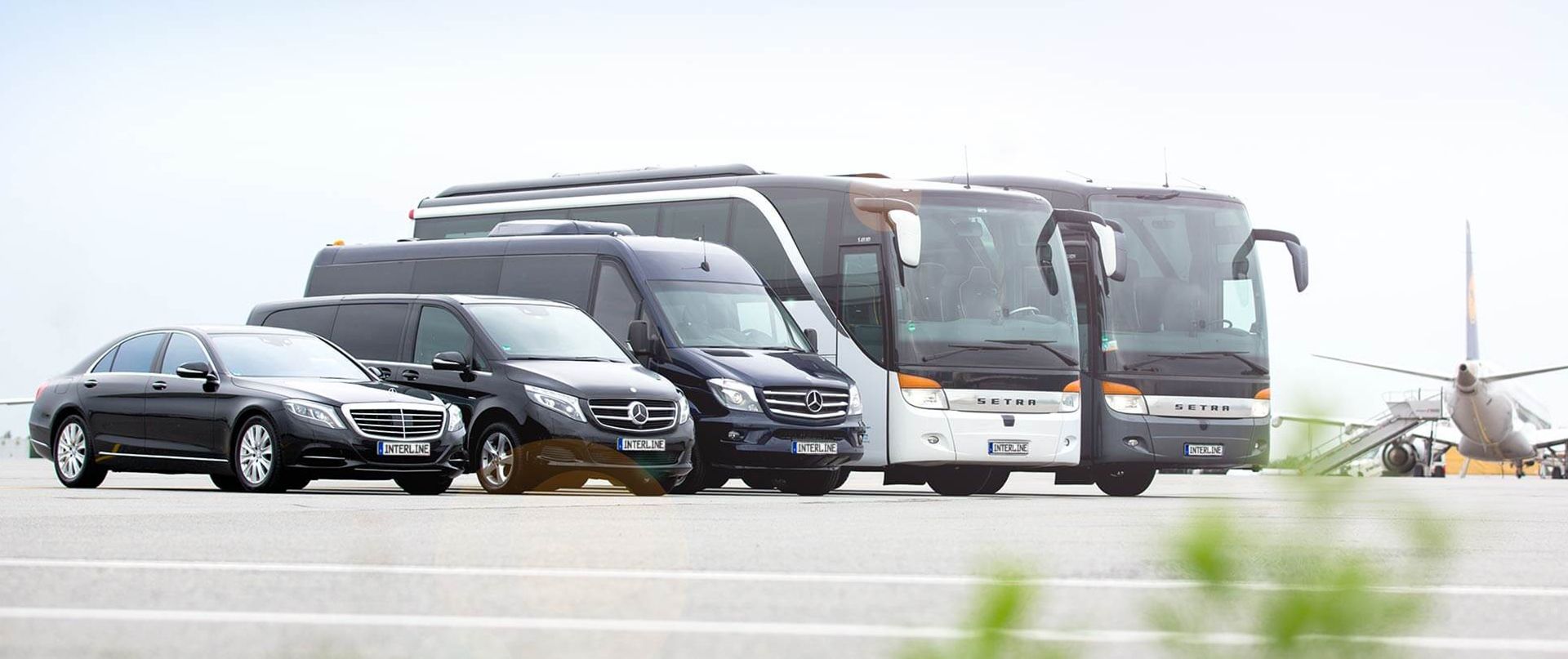 Coaches, Minivans and a Limousine on a airport.